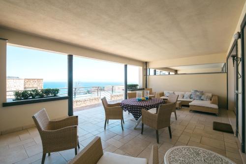 een woonkamer met een tafel en stoelen en een bank bij Taormina Chic Apartment in Taormina