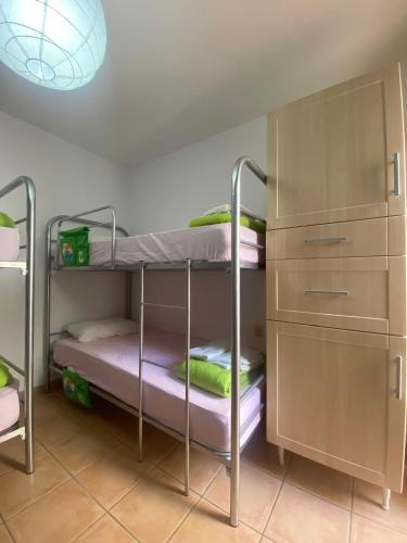 a bunk bed room with two bunk beds and a cabinet at The Best House Tenerife Habitaciones Compartidas in Adeje