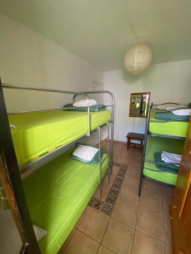 a room with two bunk beds with green at The Best House Tenerife Habitaciones Compartidas in Adeje