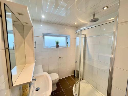 a bathroom with a toilet and a shower and a sink at Ideal 3 Bed Home In Glasgow City With Free Parking in Glasgow