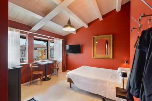 a bedroom with red walls and a bed and a desk at CABANON urban apartments in Peschiera del Garda