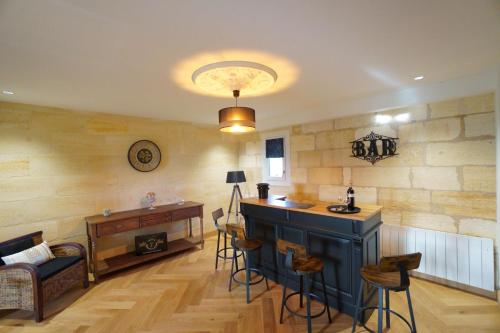 - un salon avec un bar et une table dans l'établissement La Girondine de Ferrand Lartigue, à Saint-Émilion