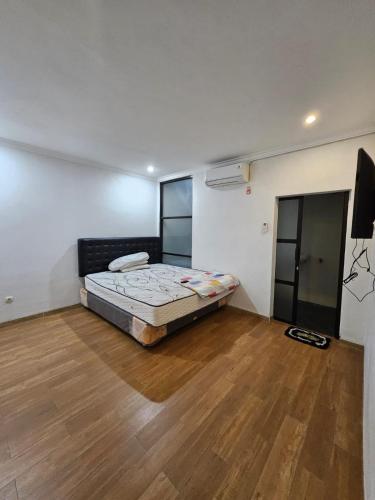 a bedroom with a bed and a wooden floor at IM Merapi Homestay in Ngaglik