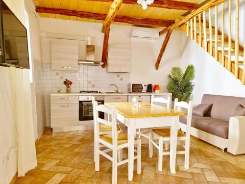 a kitchen and dining room with a table and chairs at Le Arcada - Appartamenti nel cuore del centro storico di Orosei in Orosei