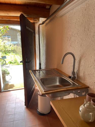 a stainless steel sink in a kitchen with an open door at Charming alps apartment perfect for walk/cycle/ski in Eschenbach
