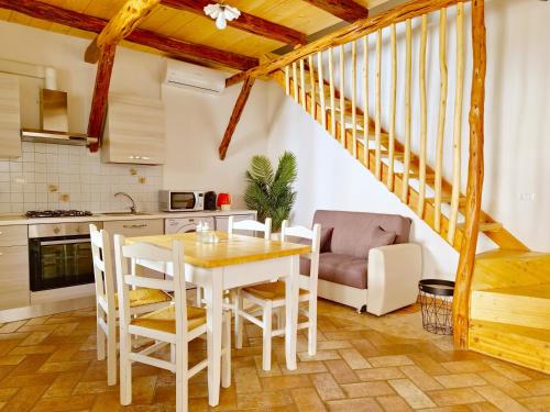 a kitchen and dining room with a table and chairs at Le Arcada - Appartamenti nel cuore del centro storico di Orosei in Orosei