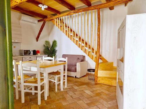 uma cozinha e sala de jantar com mesa e cadeiras em Dommos - Arcada Apartments em Orosei