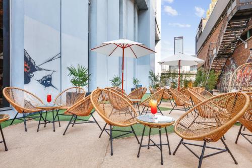 a group of chairs and tables with umbrellas on a patio at Novotel Paris Est in Bagnolet