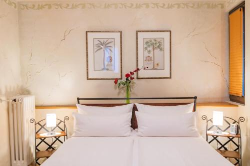 two beds with white pillows in a bedroom at Hotel Weiler in Oberwesel