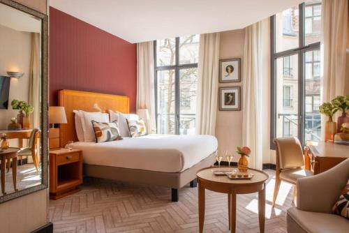 パリにあるレ ジャルダン デュ マレのベッドとソファ付きのホテルルーム
