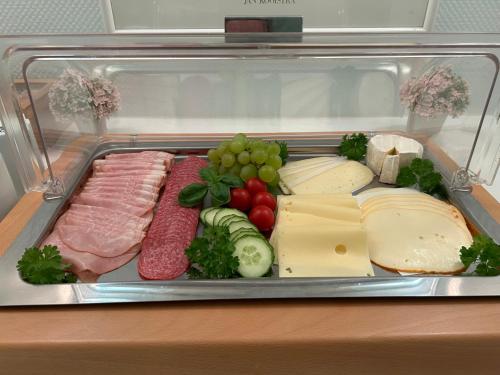 una nevera llena de diferentes tipos de carne y queso en Ferien und Freizeithof Engelau - Zi 3, en Giekau