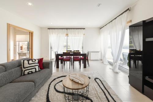 a living room with a couch and a table at Nazaré Beach House in Nazaré