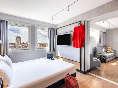 a bedroom with a bed with a red shirt hanging on a wall at ibis Strasbourg Centre Les Halles in Strasbourg