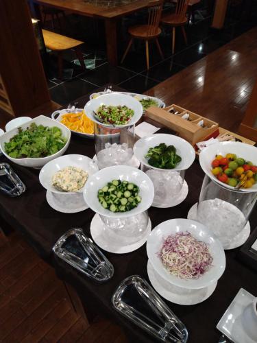 a table topped with bowls of vegetables and other foods at Rakuyu in Fujikawaguchiko