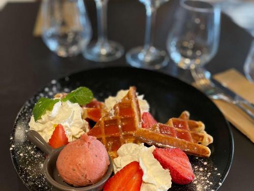 une assiette de nourriture avec des gaufres, des glaces et des fraises dans l'établissement Mercure Lyon Est Chaponnay, à Chaponnay