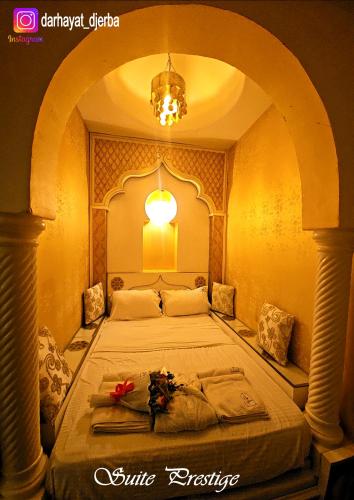una camera con un grande letto ad arco di Dar hayat a Djerba