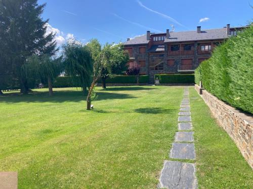 a grassy yard with a building in the background at Dúplex a Age amb piscina in Puigcerdà