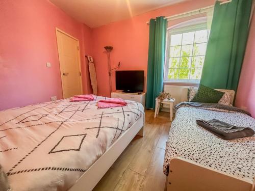 a bedroom with two beds and a television in it at 1 Bedroom Apartment By The River in High Wycombe