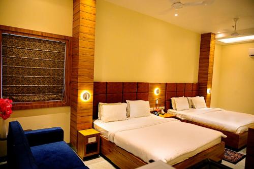 a hotel room with two beds and a couch at Cresent Villa in Varanasi