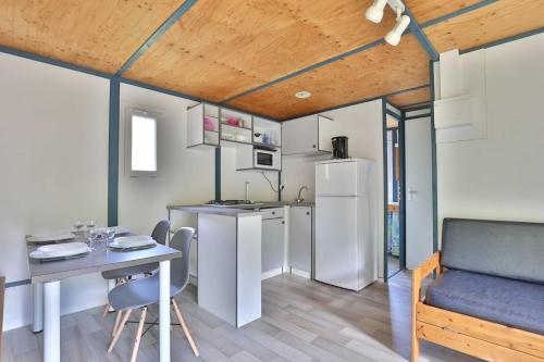 a kitchen and dining room with a table and a refrigerator at Camping L'Etang D'Ardy *** in Saint-Paul-lès-Dax
