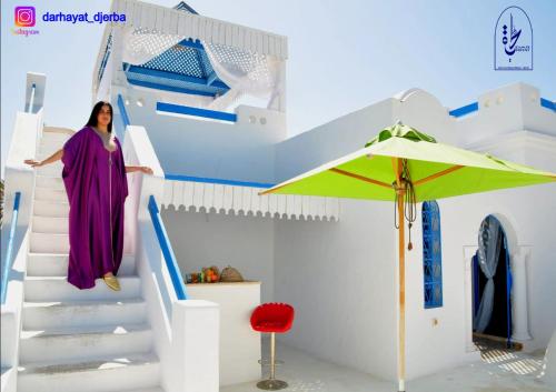 a woman walking up the stairs of a house at Dar hayat in Djerba