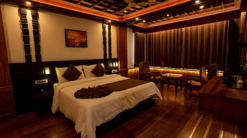 a hotel room with a bed and a table and chairs at HillView Munnar in Munnar