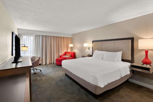 a hotel room with a bed and a red chair at Hampton Inn Lancaster in Lancaster