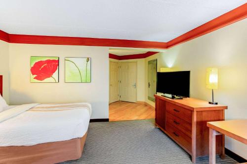 a bedroom with a bed and a flat screen tv at La Quinta by Wyndham Raleigh/Durham Southpoint in Durham