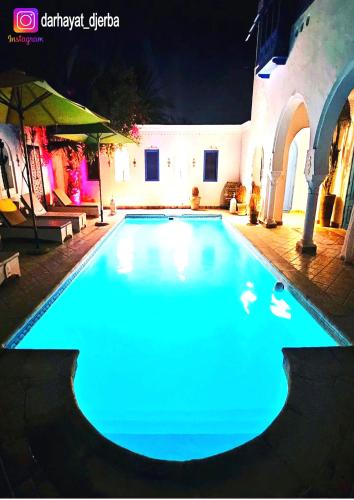 DjerbaにあるDar hayatの夜間に青い照明が灯るスイミングプール