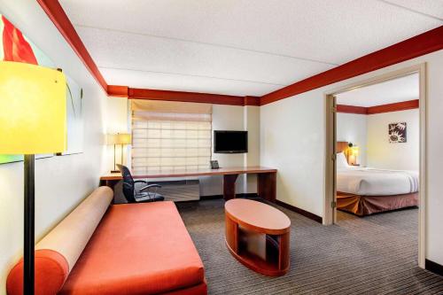 a hotel room with a couch and a bed at La Quinta by Wyndham Raleigh/Durham Southpoint in Durham