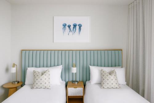 1 dormitorio con 2 camas y almohadas blancas en Kirra Point Holiday Apartments en Coolangatta