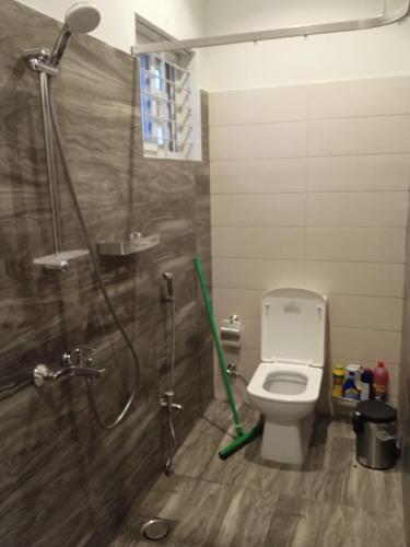 a bathroom with a shower and a toilet with a hose at Sunset BnB in Karachi