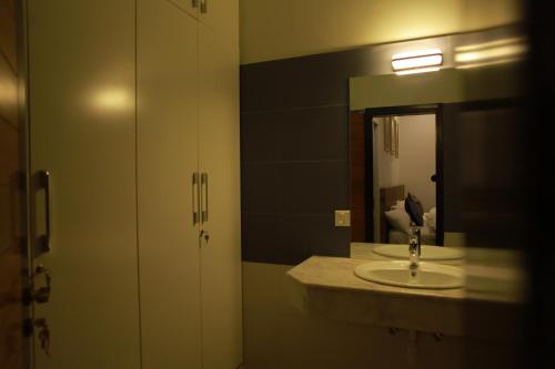 a bathroom with a sink and a mirror at Sunset BnB in Karachi