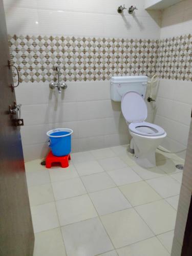 a bathroom with a toilet and a bucket in it at Hotel Atithi Galaxy in Kānpur