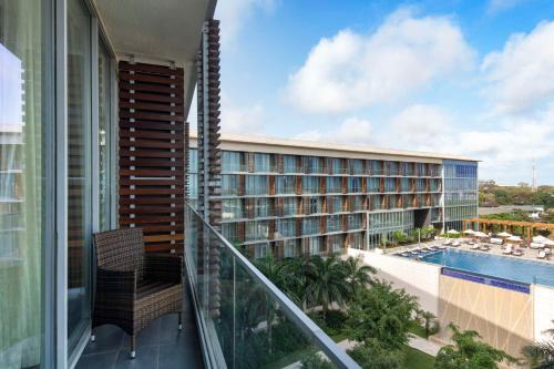 アクラにあるKempinski Hotel Gold Coast Cityのスイミングプール付きのホテルの景色を望むバルコニーが備わります。