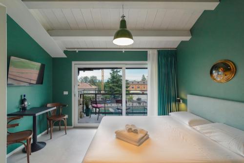 a bedroom with a bed and a desk and a window at CABANON urban apartments in Peschiera del Garda