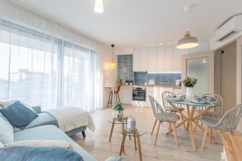 a living room with a couch and a table at Casa Romana Apartmanok Siófok By BLTN in Siófok