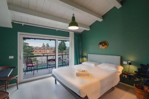 a bedroom with a large bed and a balcony at CABANON urban apartments in Peschiera del Garda