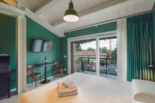 a room with a bed and a balcony with a table and chairs at CABANON urban apartments in Peschiera del Garda