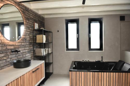 een badkamer met een zwarte wastafel en een spiegel bij Villa met 13 slaap plaatsen in Alphen