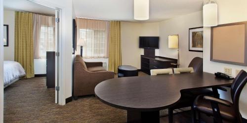 una habitación de hotel con una mesa y un dormitorio en Sonesta Simply Suites Houston Galleria Medical Center en Houston