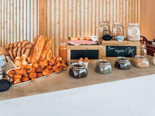 une table recouverte de beaucoup de différents types de pain dans l'établissement ibis Budget La Rochelle Centre, à La Rochelle