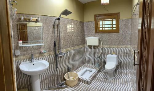 a bathroom with a shower and a sink and a toilet at The Mountain Retreat, Muzaffarabad - Families Only in Muzaffarabad