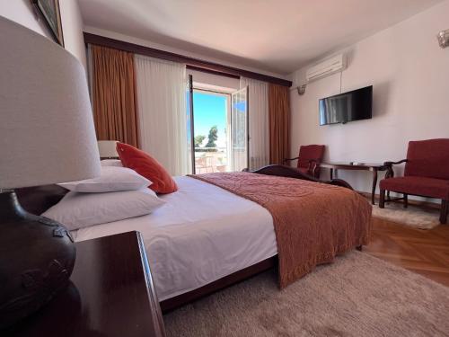Cette chambre comprend un grand lit et une fenêtre. dans l'établissement Penthouse Fantasia, à Dubrovnik