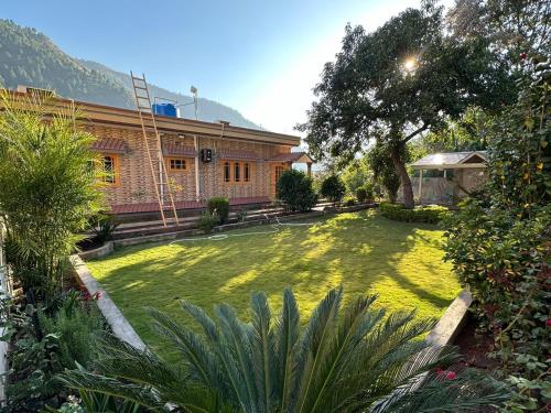a house with a yard with a grassy yard at The Mountain Retreat, Muzaffarabad in Muzaffarabad