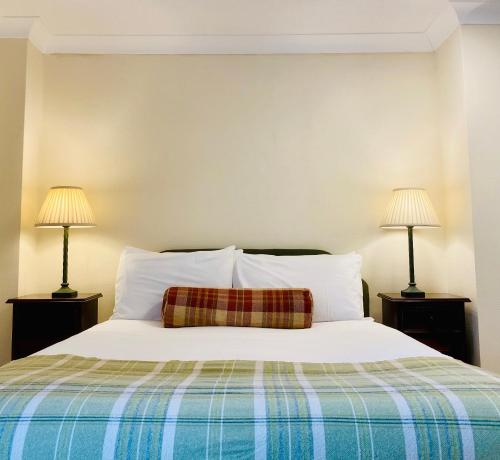 a bedroom with a white bed with two lamps at Middle House in Askrigg