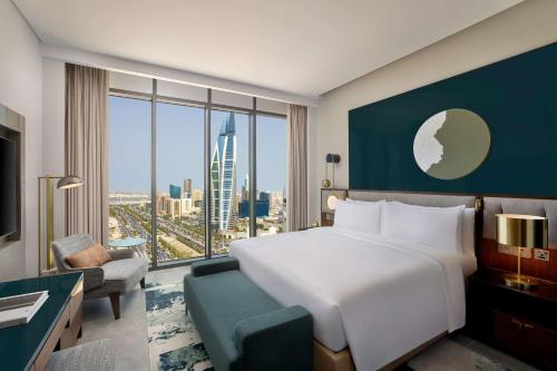 Cette chambre comprend un lit et une grande fenêtre. dans l'établissement Conrad Bahrain Financial Harbour, à Manama