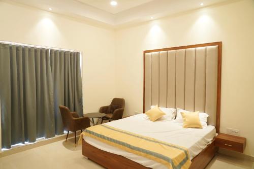 1 dormitorio con 1 cama, 2 sillas y ventana en MBS BANQUETS en Amritsar