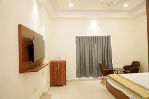 um quarto com uma cama e uma televisão de ecrã plano em MBS BANQUETS em Amritsar