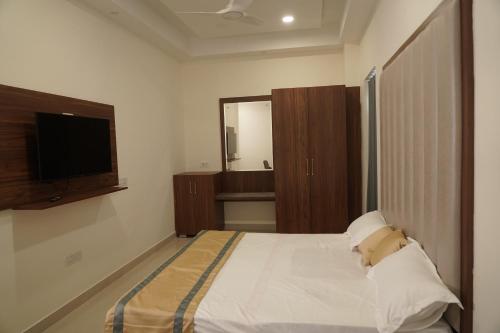 1 dormitorio con 1 cama y TV de pantalla plana en MBS BANQUETS en Amritsar
